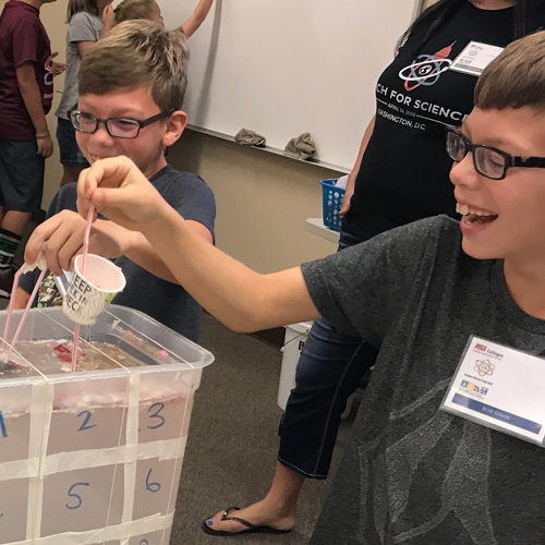 2 boys participate in water experiment at STEM academy