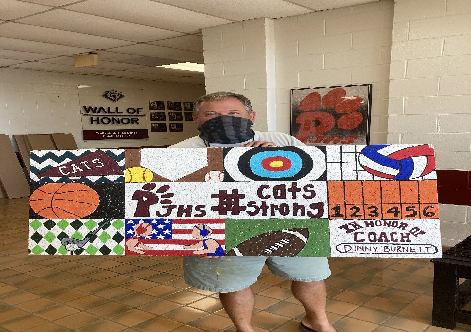 Coach Burnett holding sports themed ceiling tile created in his honor. Coach Burnett holding sports themed ceiling tile created in his honor.