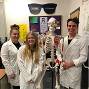 image of students in lab coats with skeleton
