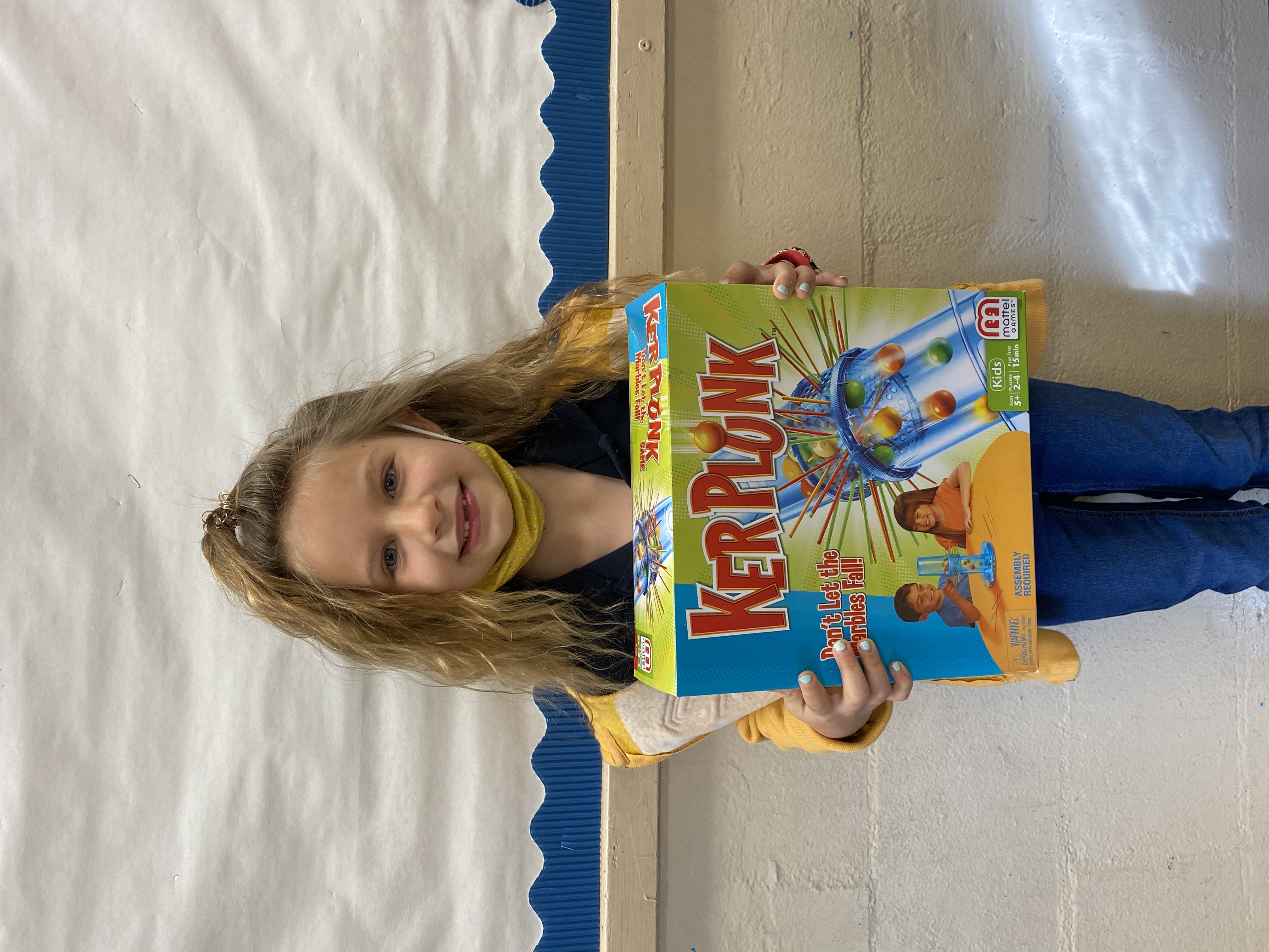 A student holding their Kerplunk Game they won.