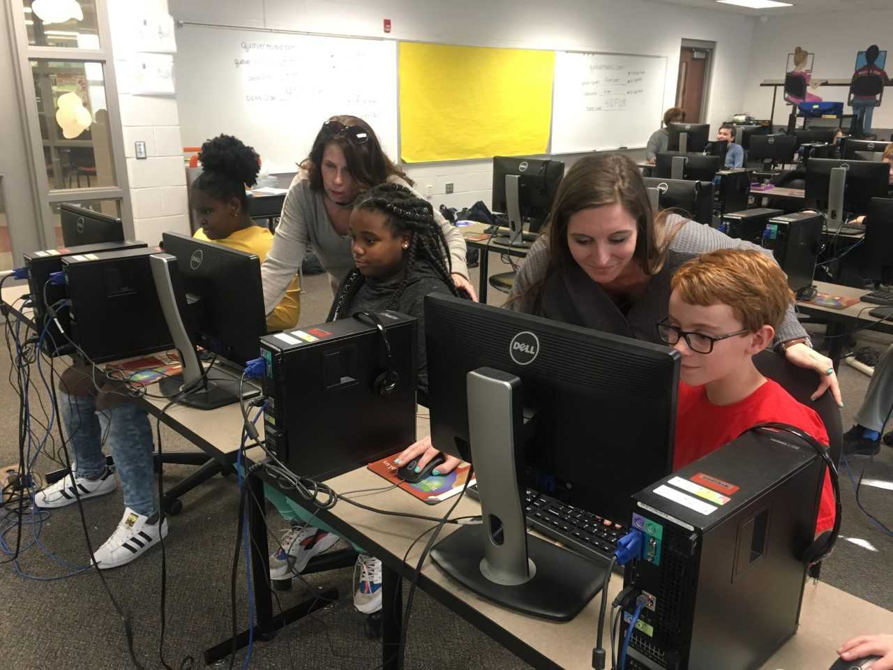 Teachers helping students on computers Teachers helping students on computers