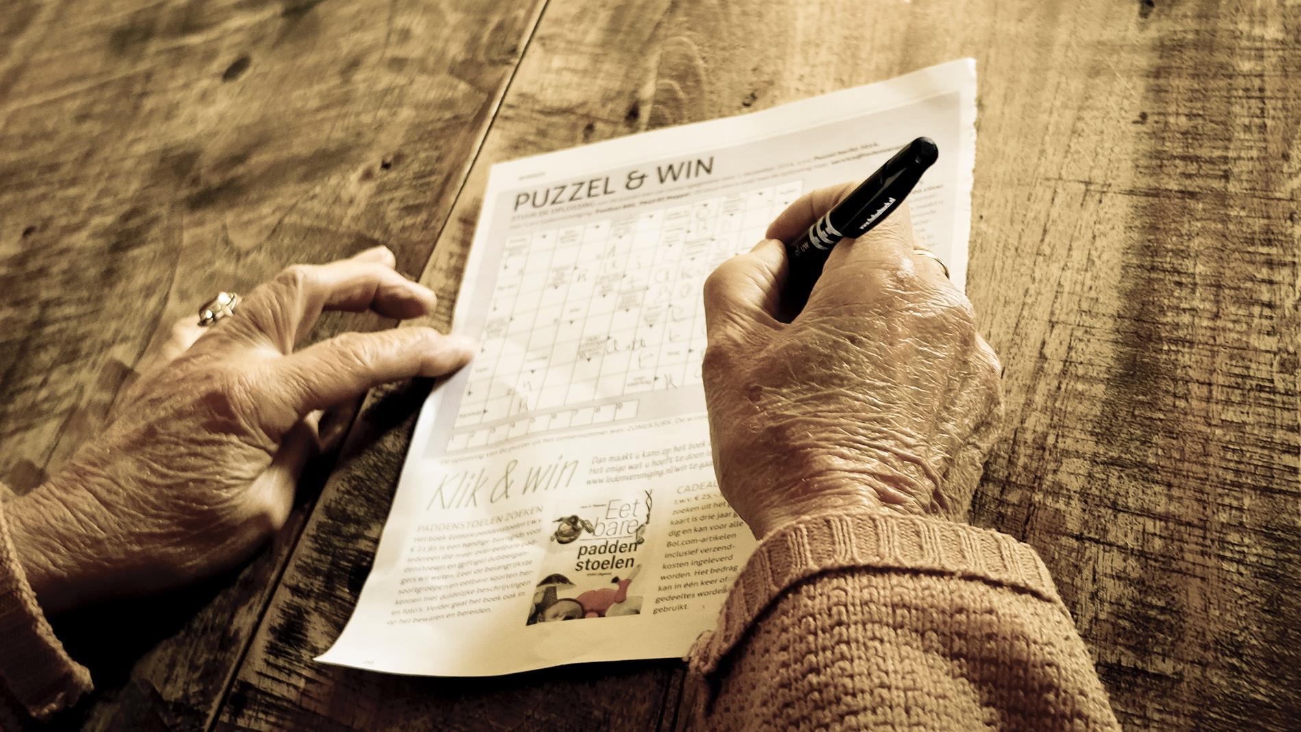 Hands of person working on an activity sheet of logic puzzles