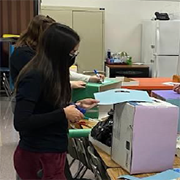 image of students working to prepare education materials