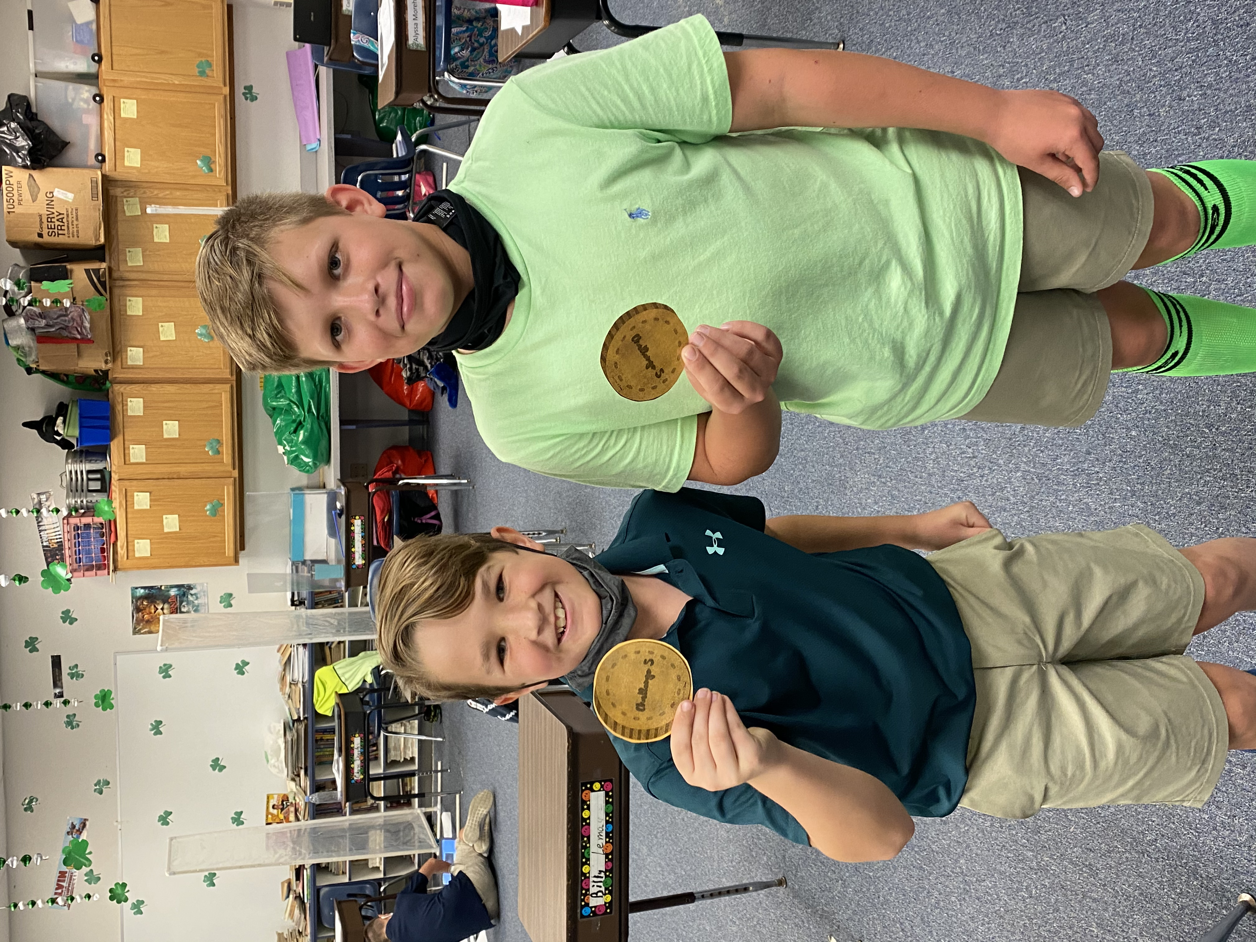 5th grade students showing the coins they earned.