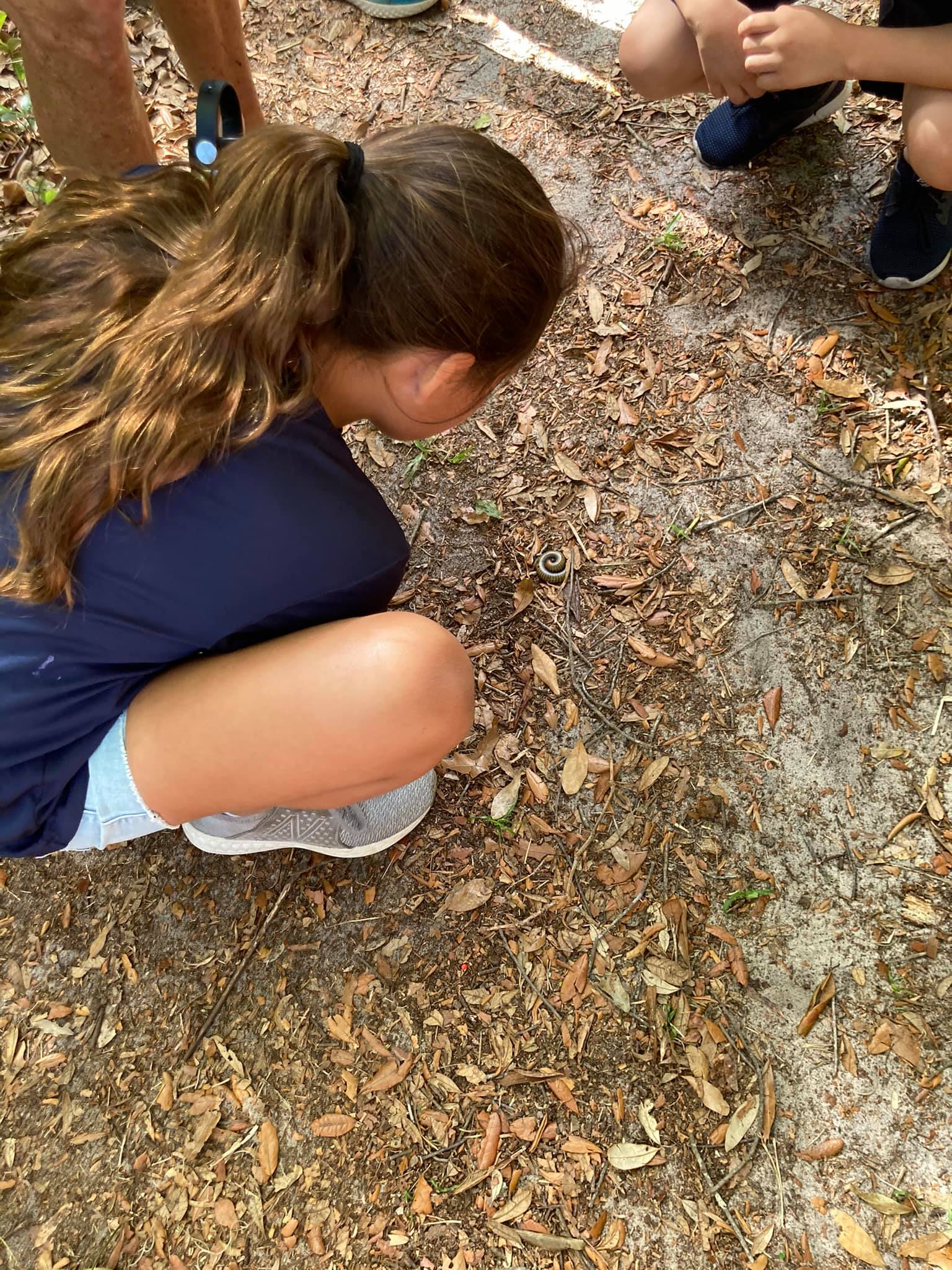 Students checking out a worm they found on one of the trails.