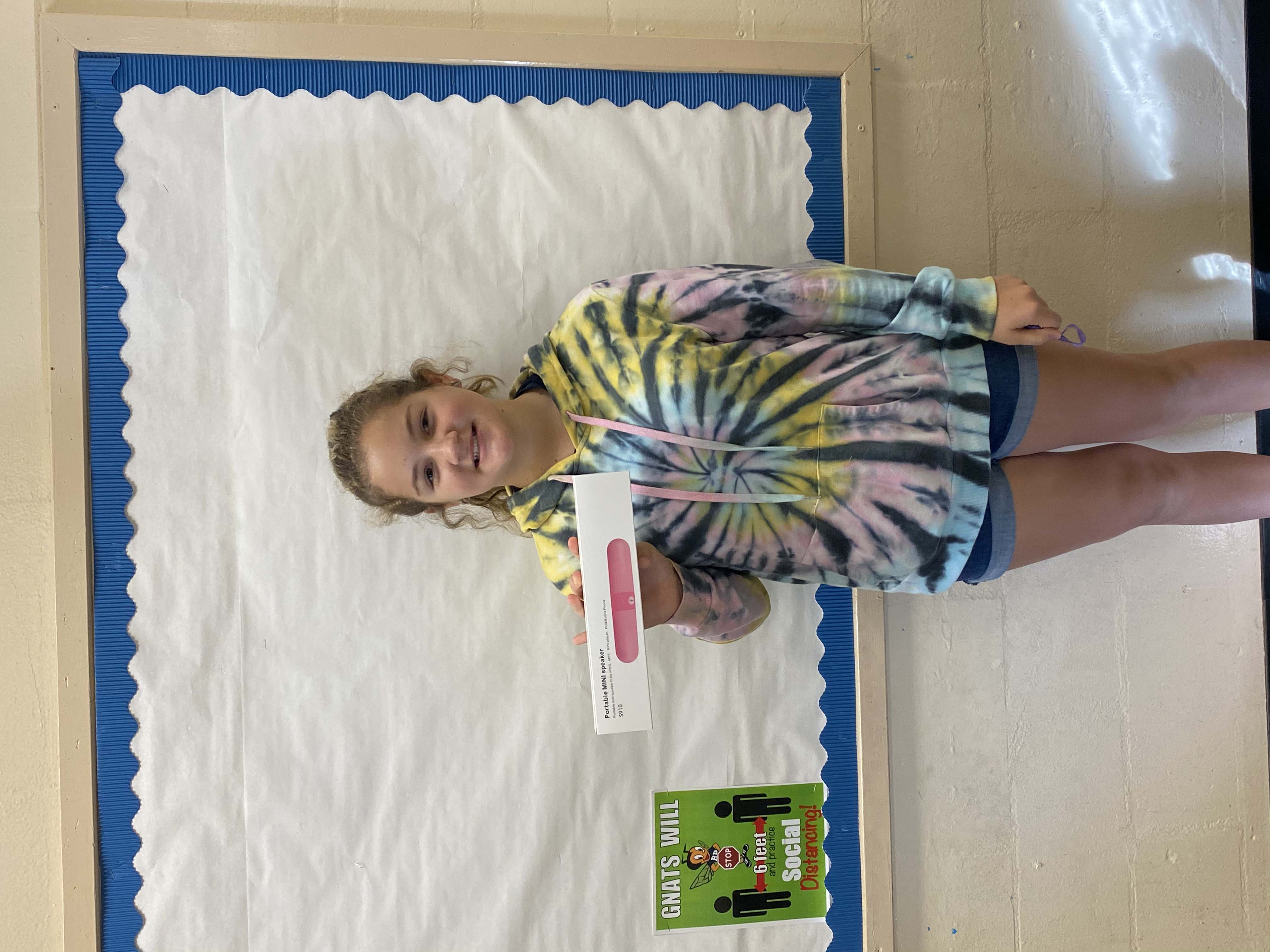 A student holding the bluetooth speaker they won.