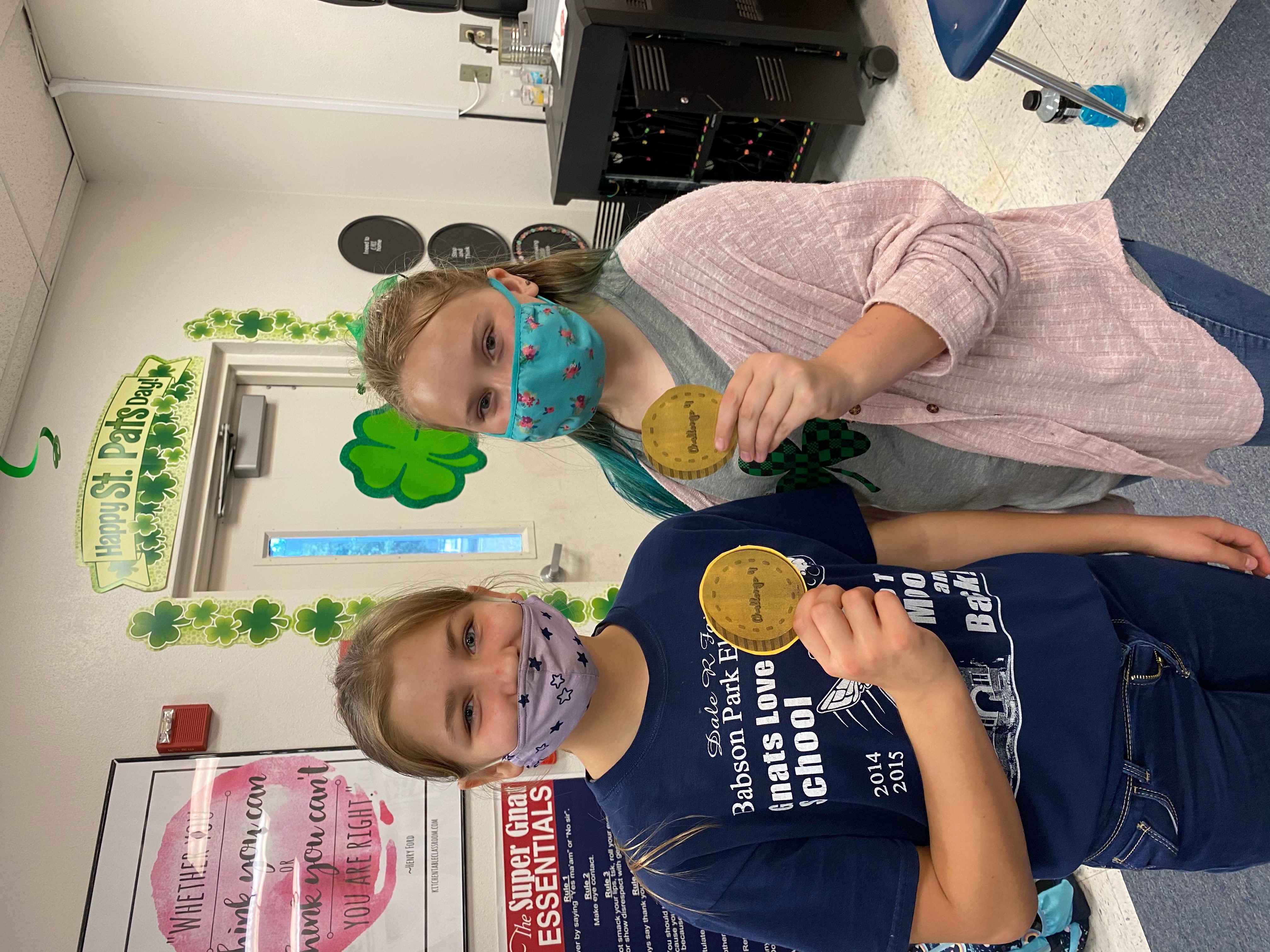 5th grade students showing the coins they earned.