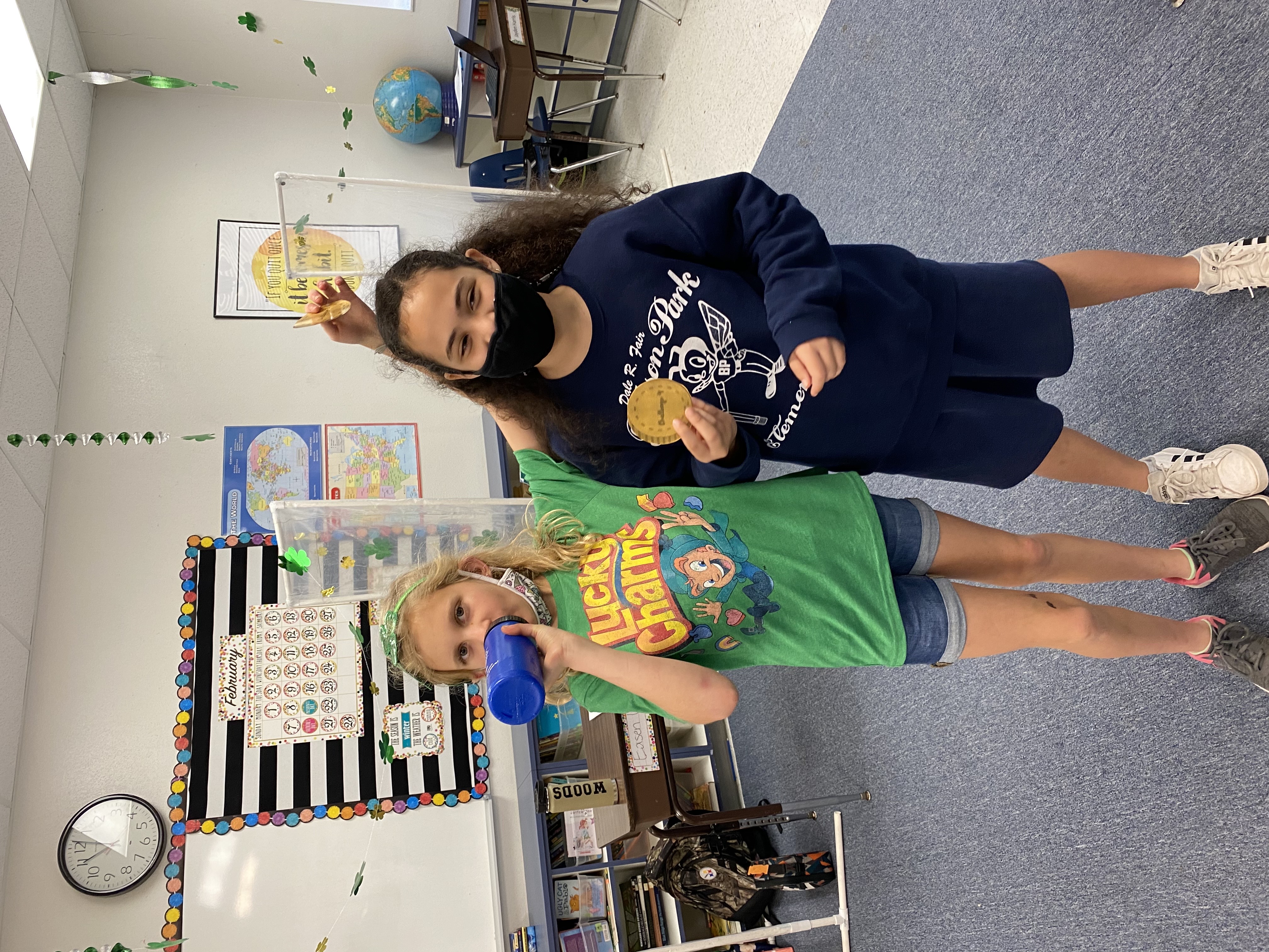 5th grade students showing the coins they earned.