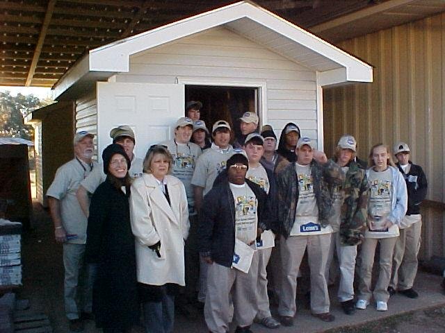 The AM Carpentry class stands proudly in front of the sheds they helped to build. 