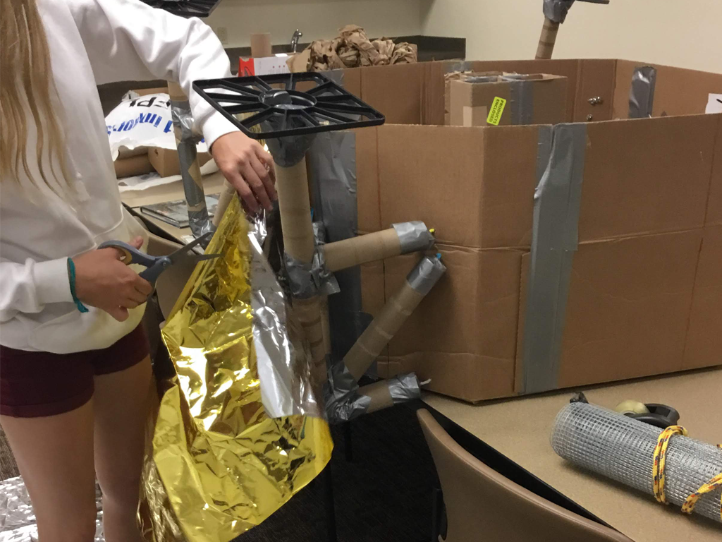 teen covering the base of the lunar module with mylar
