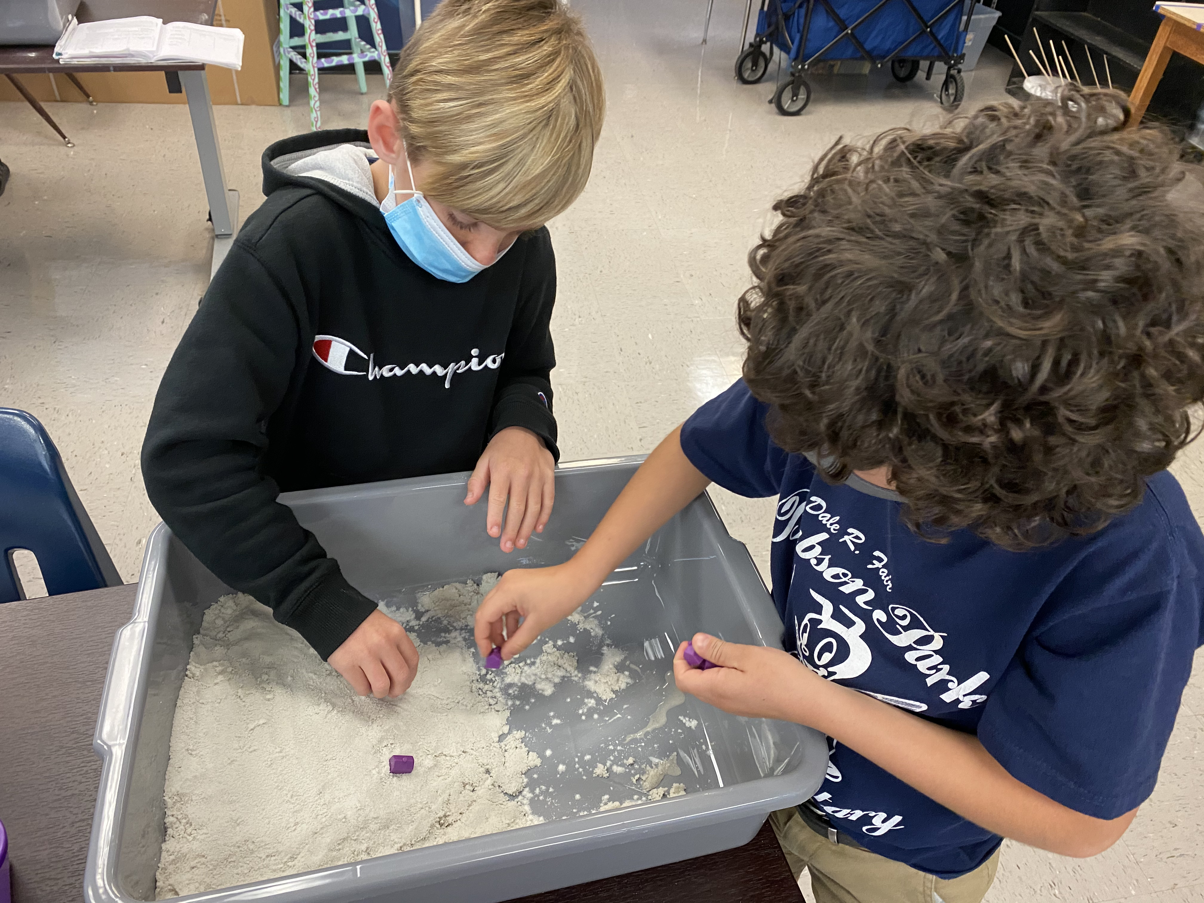 Students using sand to explore weathering and erosion
