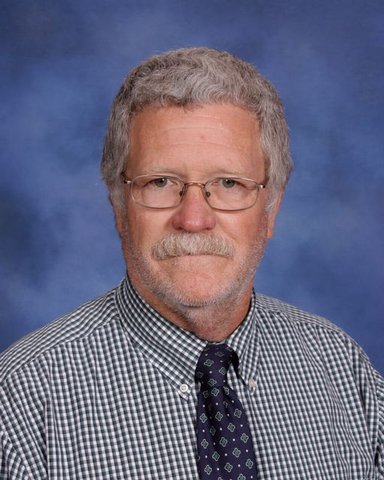 Man with glasses, gray shirt, black tie Man with glasses, gray shirt, black tie