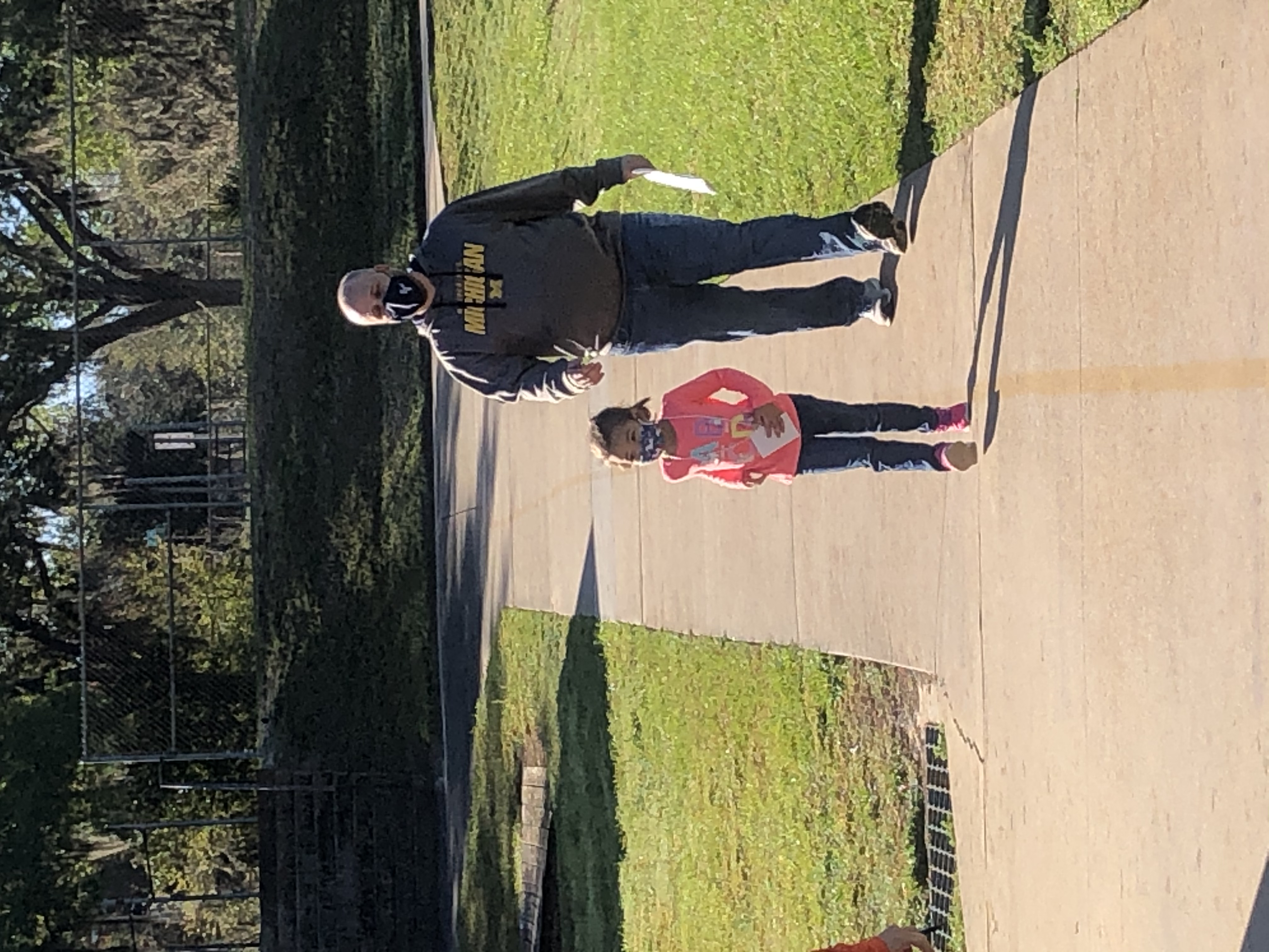 Mr. Barker and his daughter walking laps together at the Walk-a-Thon