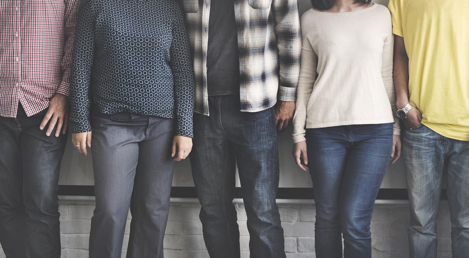 teens casually leaning against a wall, heads cropped out