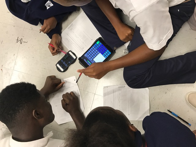 Students using devices to gather data in lab.