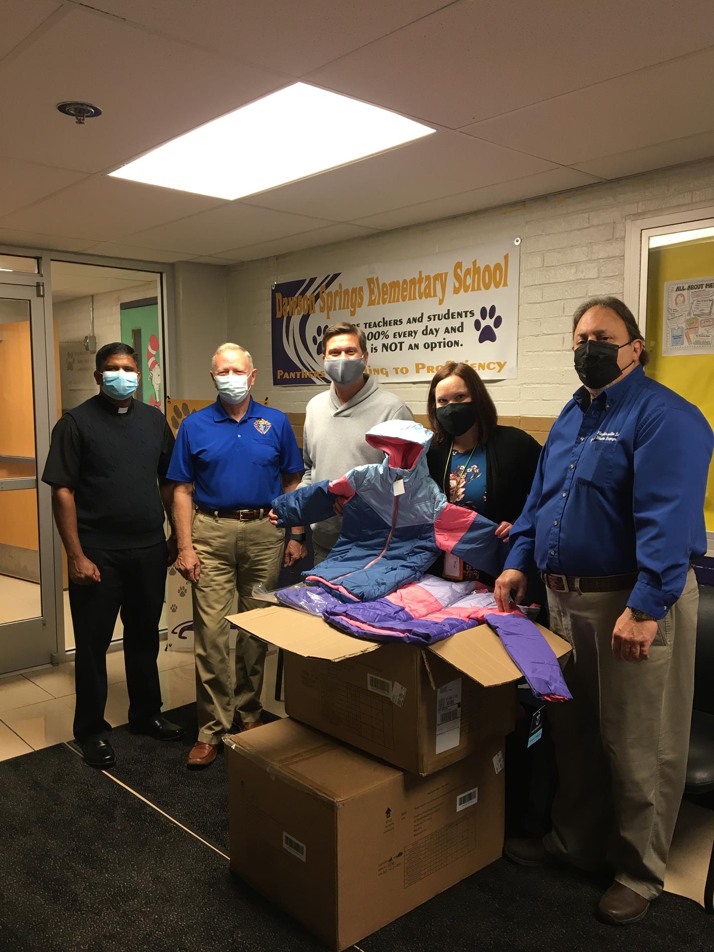 The Knights of Columbus Blessed Trinity Council donated 24 coats to the Dawson Springs Family Resource and Youth Service Center on Monday. Pictured from left are Father Jojy Joseph, District Deputy George Barber, FRYSC director Jonathon Storms, program assistant Melinda Coates and Grand Knight Tony Sicari