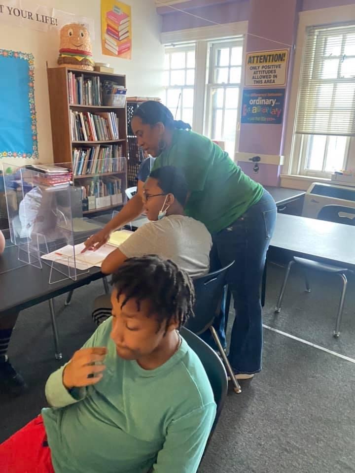 Teacher helping student read a book
