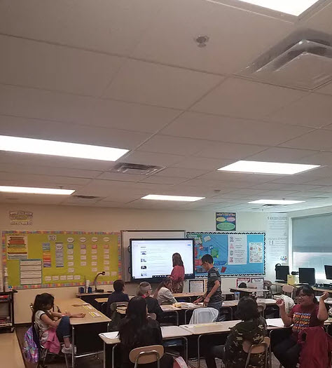 Teacher at smartboard with students in class