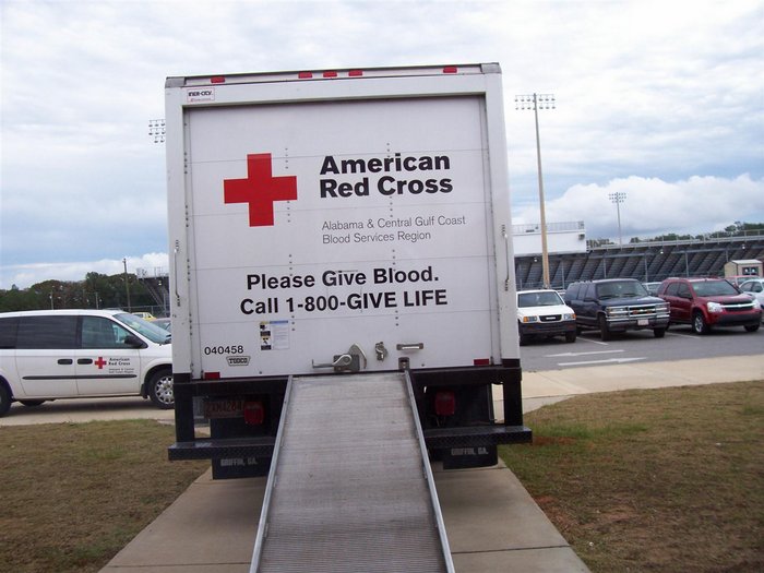 American Red Cross truck parked in front school preparing to draw blood.