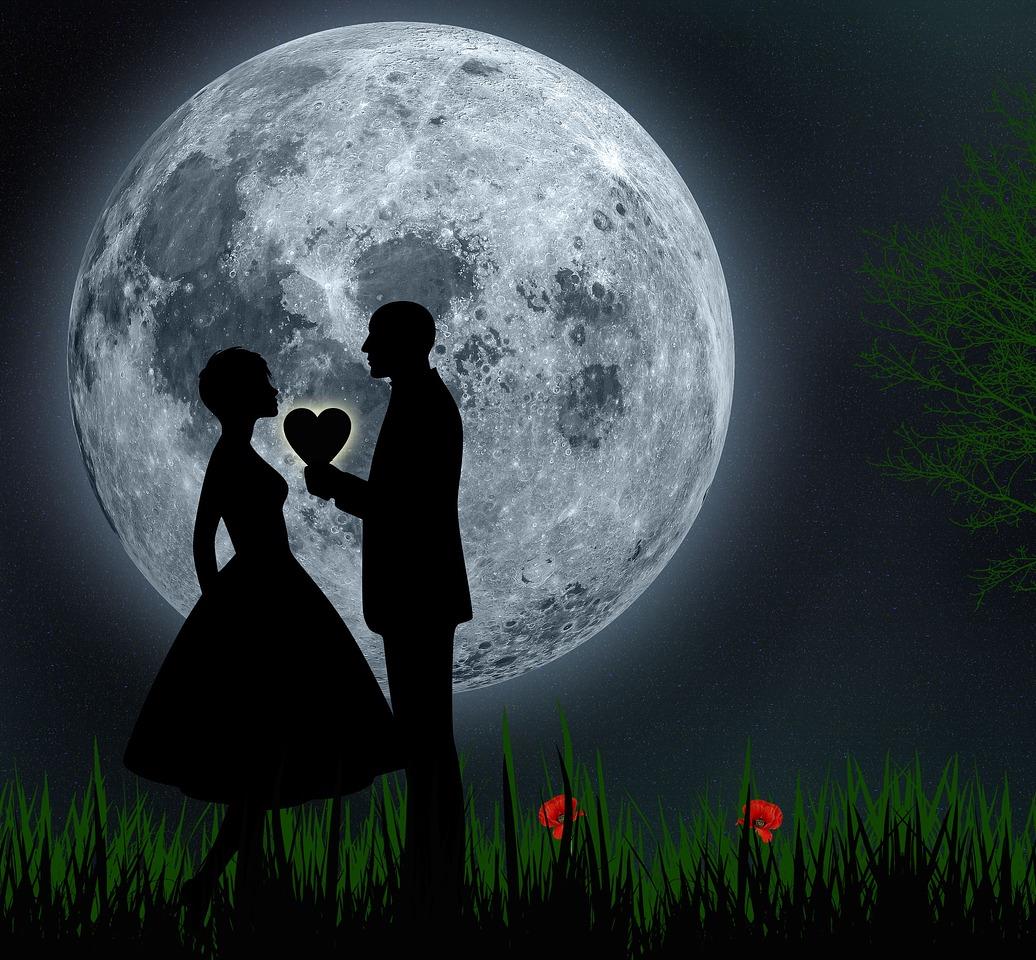 romantic couple silhouetted in front of a giant full moon