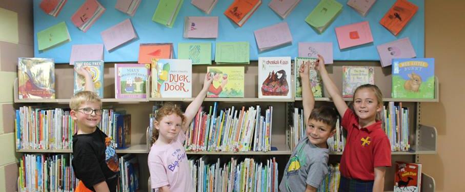 First graders show off their books after finish a nonfiction writing unit.