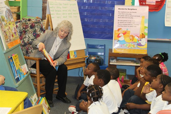 Parent sitting reading to class