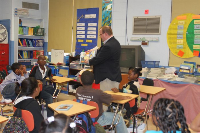 Parent standing in front of class reading